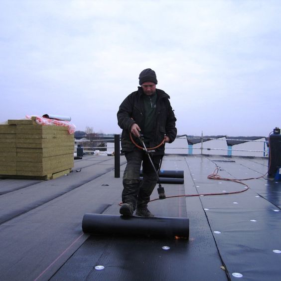 Het leggen van bitumen dakbdekking