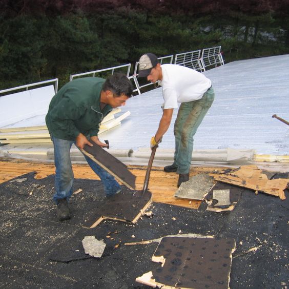 Twee mannen leggen zand op het dak